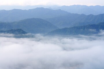 Fototapeta na wymiar foggy clouds and mountains in blue tones before sunrise