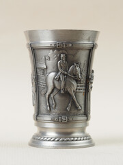 Traditional German vintage pewter wine glass with a bas-relief depicting a rider on horseback - 556173483