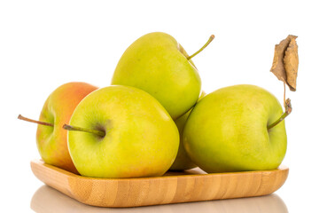 Several green sweet apple on bamboo plate, macro, isolated on white background.