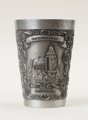 Traditional German vintage pewter wine glass with a bas-relief depicting the collegiate church building in the city of Herrenberg - 556173624
