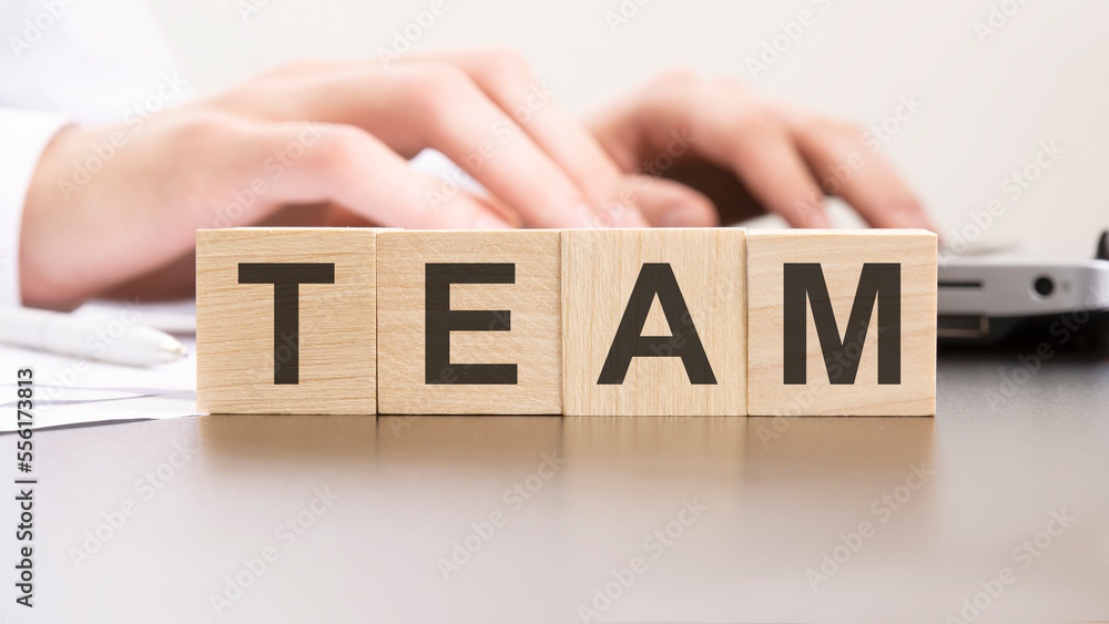 Poster man made word team with wood blocks on the background of the office table. selective focus. business