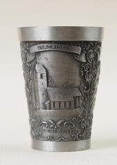 Traditional German vintage pewter wine glass with a bas-relief depicting the evangelical church of Saint Veit in the town of Gartringen - 556173810