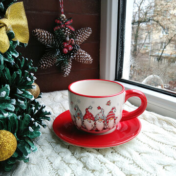 beautiful Christmas cup with gnomes for hot drinks: tea, coffee, cocoa or cappuccino against the background of cones, windows and stars. home decorations for christmas and new year celebration