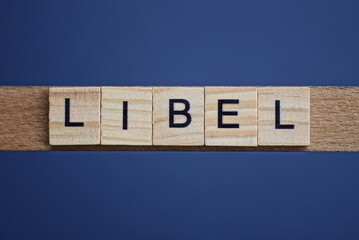text the word libel from brown wooden small letters on a black table