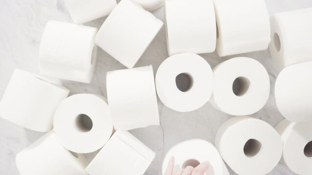 Flat lay. New white toilet paper rolls on a gray background.
