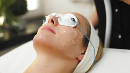 professional beautician making non-surgical face lifting procedure for a client, beauty center. High quality 4k footage