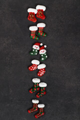 Holiday sweets. Cute Candy in the shape of Christmas socks, covered with colored icing sugar. Dark gray background. Top view