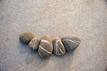 Beautiful beige beach stones laid on slab stone. 