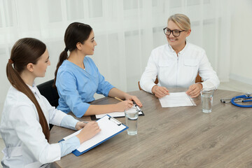 Obraz premium Medical conference. Doctors working at wooden table in office