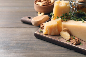 Delicious parmesan cheese served with honey, walnuts and thyme on wooden table, closeup. Space for text