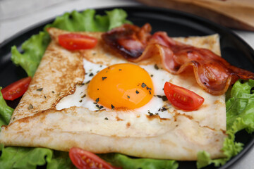 Delicious crepe with egg on plate, closeup. Breton galette