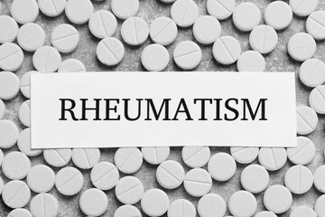 Card with word Rheumatism and pills on light gray background, flat lay
