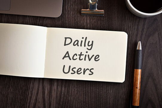 There Is Notebook With The Word Daily Active Users. It Is An Eye-catching Image.