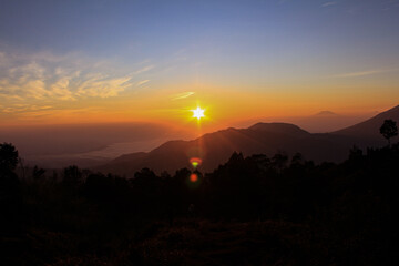 Sunrise Peeking from above the Clouds on the Mountains