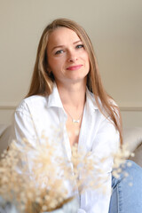 Portrait of enjoying blonde woman indoors. Satisfied caucasian woman with long hair is relaxing. Eyes closed portrait