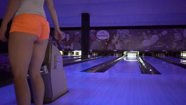 Girl Throws Bowling Ball In Bowling Club