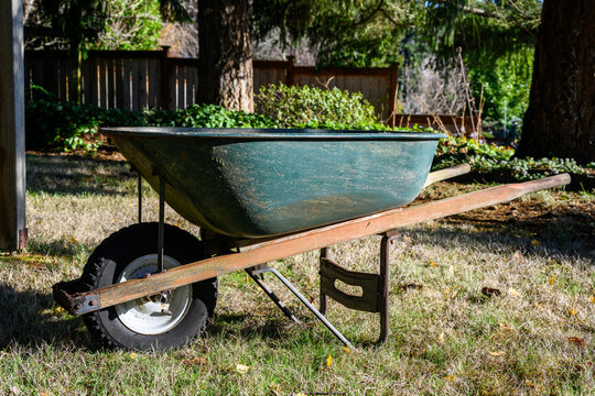 Metal wheelbarrow with a warn out tire, well used gardening tool
