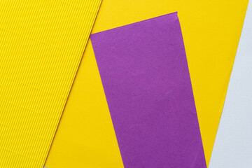 smooth and corrugated paper background in yellow, purple, and white