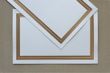 two elegant gold foil embossed invitation cards on corrugated paper