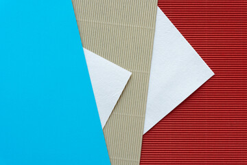 smooth and corrugated paper background in blue, beige, and red with added decorative triangle shapes