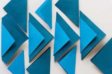 collection folded blue paper tiles on blank paper