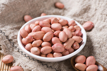 raw peanuts or groundnut in plate on table.