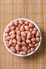 raw peanuts or groundnut in plate on table.