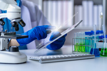 scientist research in medical science laboratory Medical technology with biology or chemical liquid in a glass tube with a microscope. In the lab.