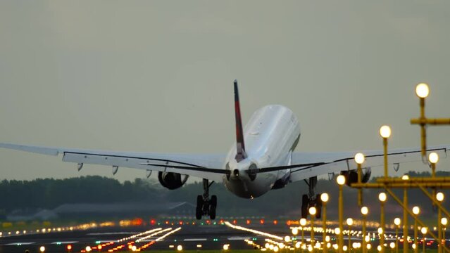 Cinematic footage airplane landing and braking. Landing lights illuminate the runway. Tourism and travel concept