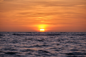 Ocean sunset. Big white sun on dramatic bright sky background, soft evening horizont over sea dark water