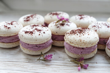 macarons with purple cream and lemon curd in a wooden box on a light background