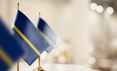 Small flags of the Nauru on an abstract blurry background