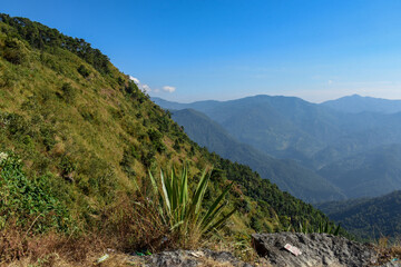 Landscape with mountains and crisp cloudy blue sky.
