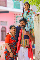 Fototapeta na wymiar Happy indian farmer couple with daughter at home.
