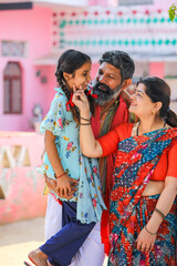 Happy indian farmer couple with daughter at home.