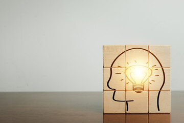 Creative idea and innovation,New ideas,Education,inspiration,brainstorm Concept.,Light bulb in head icon on wooden cubes over white background.