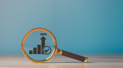 A magnifying glass is placed on the table,business growth and success graph concept of progress in development Financial efficiency and investment with business strategies for goals.