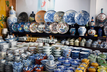 Famous Arita porcelain - dishes and vases of various shapes decorated with underglaze blue in a store in Arita, Japan, expensive luxury ware, traditional kaolin clay pottery - obrazy, fototapety, plakaty