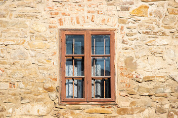 Fototapeta na wymiar an old window on a stone wall seen from the outside