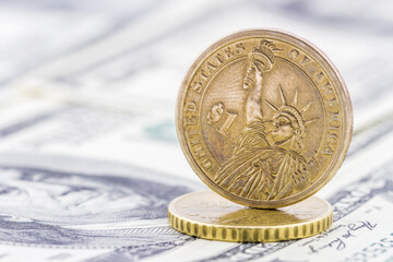 Close-up view of one Dollar coin on banknotes background