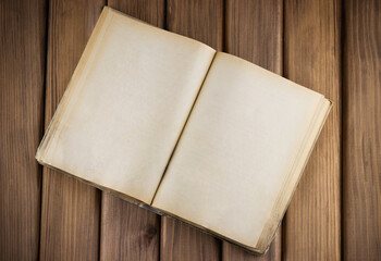 Top view of blank open old book with grange pages on wooden background