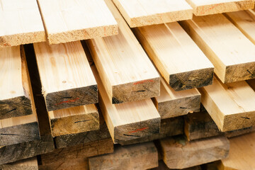 Wooden boards are stacked in a sawmill or carpentry shop. Sawing drying and marketing of wood. Industrial background.