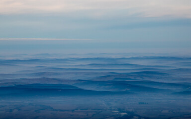 Naklejka na ściany i meble Aerial view with many hills shrouded in fog