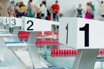 Starting table with numbers for diving in Olympic pool. Swimming pool for competitions with lane...