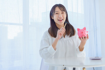 貯金箱を割ろうとする女性