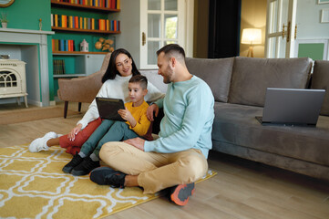 Happy family using mobile tablet at home together