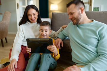 Happy family using mobile tablet at home together