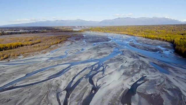 Shadow of a cloud passes over Alaska's Knik River on sunny autumn day