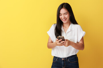 Portrait of positive cheerful girl use smart phone share social media news wear style stylish trendy isolated over yellow color background