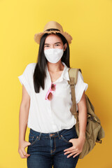 Beautiful travel asian woman with facemask isolated on yellow background